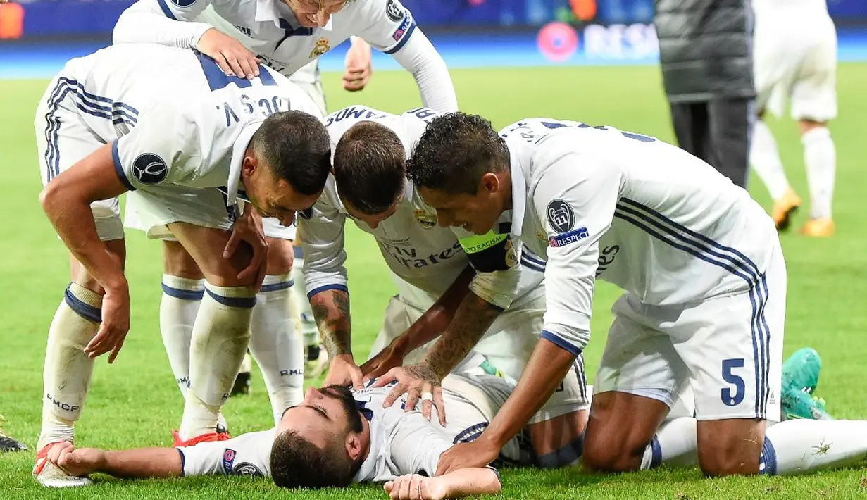 Pemain Real Madrid, Daniel Carvajal, disambut rekan-rekannya setelah mencetak gol penentu kemenangan atas Sevilla pada laga Piala Super Eropa 2016 di Stadion Lerkendal, Rabu (10/8/2016) dini hari WIB. (AFP/Jonathan Nackstrand)