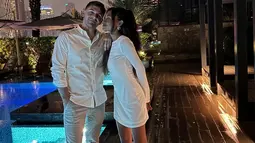 Novia tampil menawan mengenakan mini dress putih bertekstur yang memperlihatkan siluet tubuhnya dengan anggun. Ia juga memakai sandal hak tinggi berwarna nude, menambah kesan feminin dan classy. Sementara itu, sang kekasih memakai setelan yang rapi. (Liputan6.com/IG/@noviabachmid)