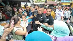  Sejumlah warga berebut untuk bersalaman dengan Cagub DKI Jakarta, Agus Harimurti Yudhoyono, Jakarta, Senin (28/11). Agus Harimurti Yudhoyono temui warga dan pedagang di Pasar Sumur Batu. (Liputan6.com/Yoppy Renato)