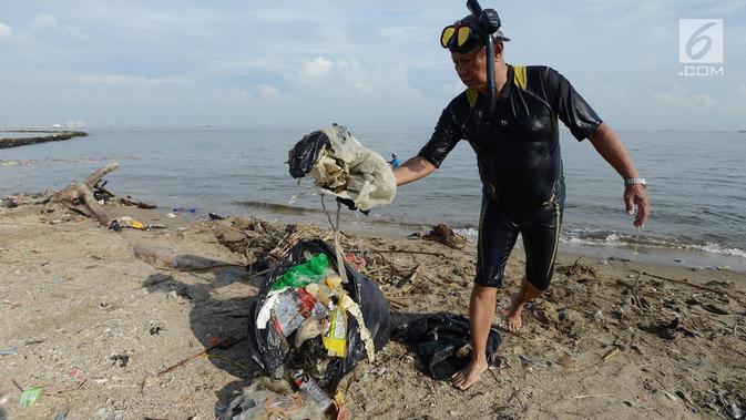 Prajurit TNI AL dengan pakaian selam membersihkan sampah di kawasan Pantai Ancol, Jakarta, Jumat (1/3). Sekitar 400 orang yang diterjunkan untuk membersihkan pesisir laut dengan garis pantai sepanjang 300 meter itu. (Merdeka.com/ Imam Buhori)