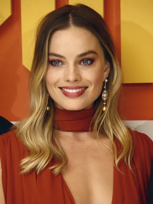 Aktris Margot Robbie tersenyum saat menghadiri premier film Once Upon a Time In Hollywood di sebuah bioskop di London, Inggris (30/7/2019). Margot Robbie tampil seksi menggenakan gaun oranye tipis Oscar de la Renta untuk menyesuaikan musim panas di eropa. (AP Photo/Joel C Ryan)