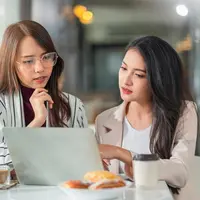 Dua orang perempuan sedang berdiskusi sambil melihat ke arah laptop (Foto Dok: Freepik/ Lifestylememory).