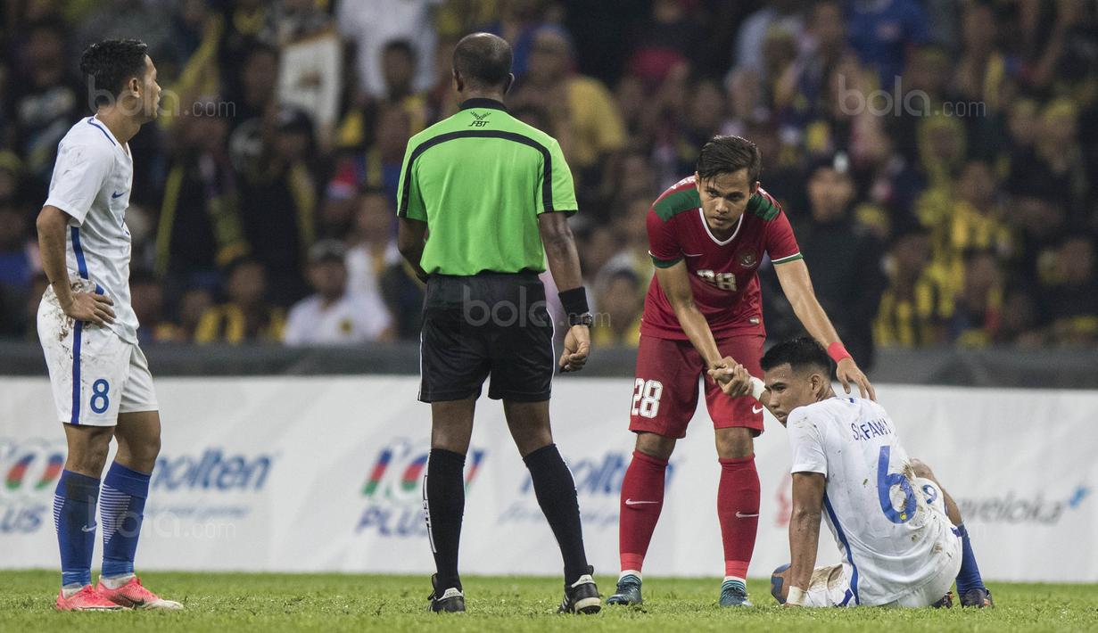 Bek Timnas Indonesia, Rezaldi Hehanusa, mengulurkan tangan membantu pemain Malaysia yang kesakitan saat laga semifinal SEA Games di Stadion Shah Alam, Selangor, Sabtu (26/8/2017). Indonesia kalah 0-1 dari Malaysia. (Bola.com/Vitalis Yogi Trisna)