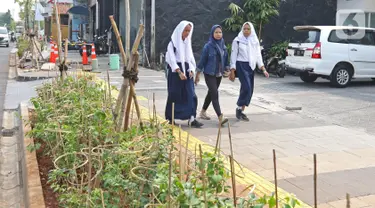 Pelajar melintasi trotoar di kawasan Kemang, Jakarta, Selasa (15/10/2019). Pemerintah Provinsi DKI menargetkan pelebaran dan penataan trotoar ini akan rampung pada Desember 2019. (Liputan6.com/Herman Zakharia)