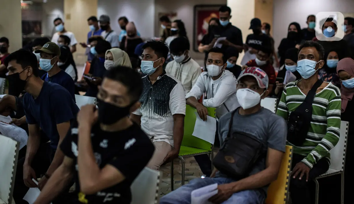 Pedagang antre mengikuti vaksinasi massal di Pasar Tanah Abang, Jakarta, Sabtu (31/7/2021). Menko Marves Luhut Binsar Pandjaitan meminta Kemenkes bersama TNI-Polri terus mempercepat program vaksinasi COVID-19 hingga mencapai dua juta suntikan per hari mulai Agustus 2021. (Liputan6.com/Johan Tallo)