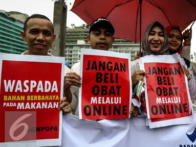 Peserta aksi membawa poster saat mengikuti kampanye Gerakan Peduli Obat dan Pangan Aman di kawasan Car Free Day Bundaran HI, Jakarta, Minggu (13/11). (Liputan6.com/Faizal Fanani)