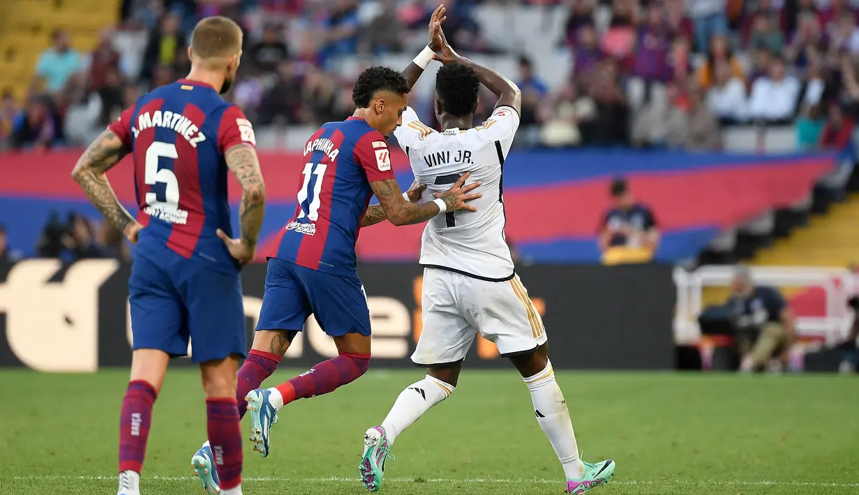 Pada menit ke-90+5,  Real Madrid memutuskan untuk mengganti Vinicius Junior dengan Lucas Vazquez yang sudah siap di pinggir lapangan. Akan tetapi, Vinicius berusaha mengulur waktu dan tampak berjalan lambat yang akhirnya dibantu oleh pemain Barcelona, Raphinha agar rekan senegaranya tersebut bisa keluar lapangan dengan cepat. (AFP/Josep Lago)