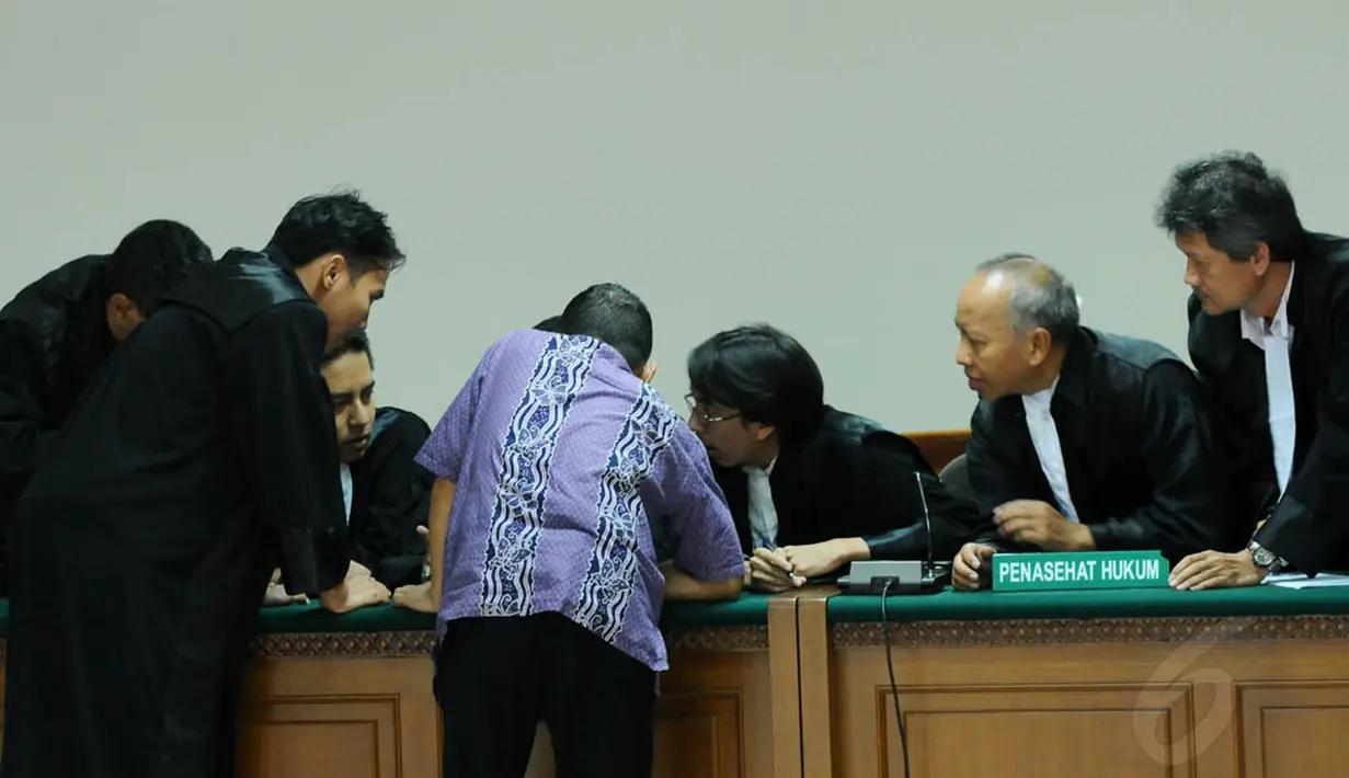 Hendra Saputra tampak berdiskusi dengan tim pengacaranya, Jakarta, Rabu (27/8/14). (Liputan6.com/Andrian M Tunay)