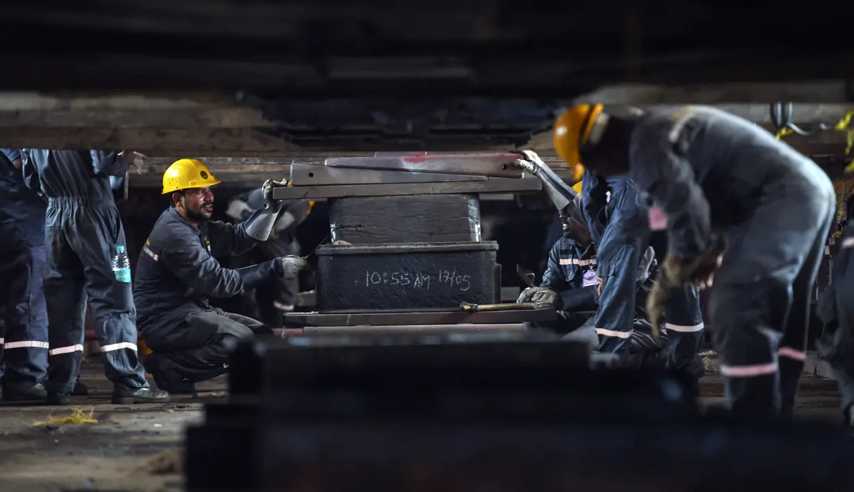 Para pekerja bersiap untuk upacara peluncuran kapal perang INS Udaygiri di halaman Mazagaon Dock Shipbuilders Limited, Mumbai, India, Selasa (17/5/2022). (Punit PARANJPE/AFP)