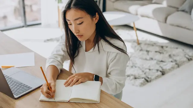 Seorang perempuan sedang menulis sebuah jurnal (Foto Dok: Freepik/senivpetro)