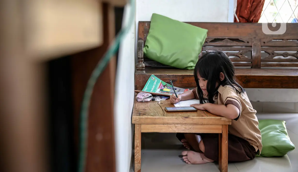 Seorang siswi memperhatikan ponsel saat belajar secara daring di Jakarta, Rabu (4/11/2020). Federasi Serikat Guru Indonesia merekomendasikan sejumlah usulan kepada Kementerian Pendidikan dan Kebudayaan untuk mengubah sistem Pembelajaran Jarak Jauh. (Liputan6.com/Faizal Fanani)