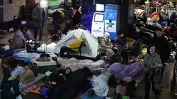 Stasiun bawah tanah terus berfungsi sebagai tempat perlindungan utama bagi warga Kyiv untuk menghindari bahaya serangan udara Rusia. Tampak dalam foto, orang-orang berlindung di stasiun metro saat serangan udara Rusia di Kyiv pada Selasa 25 November 2025, di tengah invasi Rusia ke Ukraina. (Yan Dobronosov/AFP)