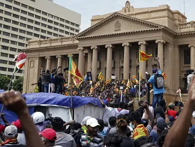 Para pengunjuk rasa, banyak yang membawa bendera Sri Lanka, berkumpul di luar kantor presiden di Kolombo, Sri Lanka, 9 Juli 2022. Ribuan pengunjuk rasa di Sri Lanka telah menerobos barikade polisi dan menyerbu kediaman resmi presiden di salah satu protes anti-pemerintah terbesar di negara yang dilanda krisis tahun ini. (AP Photo/Thilina Kaluthotage)