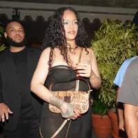 Rihanna tampak mengenakan black strappy dress semi transparan. Nuansa warna biru laut pada eye makeup dan beberapa aksesori emas yang dikenakannya membuat penampilannya ini semakin terlihat serasi.