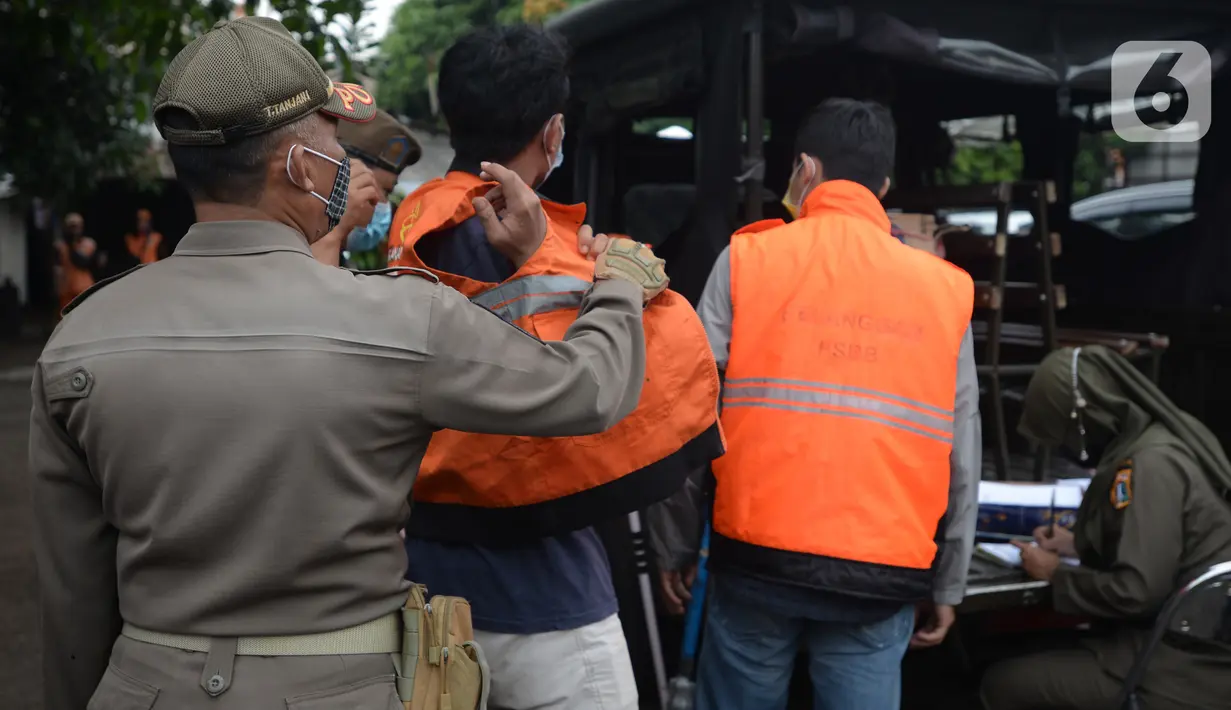 Warga yang terjaring razia protokol kesehatan COVID-19 mengenakan rompi di Kebon Nanas, Jakarta, Selasa (15/6/2021). Saat kasus positif Covid-19 di Jakarta meningkat, masih banyak warga yang belum menjalankan protokol kesehatan, salah satunya mengenakan masker. (merdeka.com/Imam Buhori)