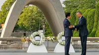 Presiden AS Barack Obama dan Perdana Menteri Jepang Shinzo Abe berjabat tangan setelah meletakkan karangan bunga di cenotaph di Taman Peringatan Perdamaian Hiroshima pada 27 Mei 2016. (AP Images)