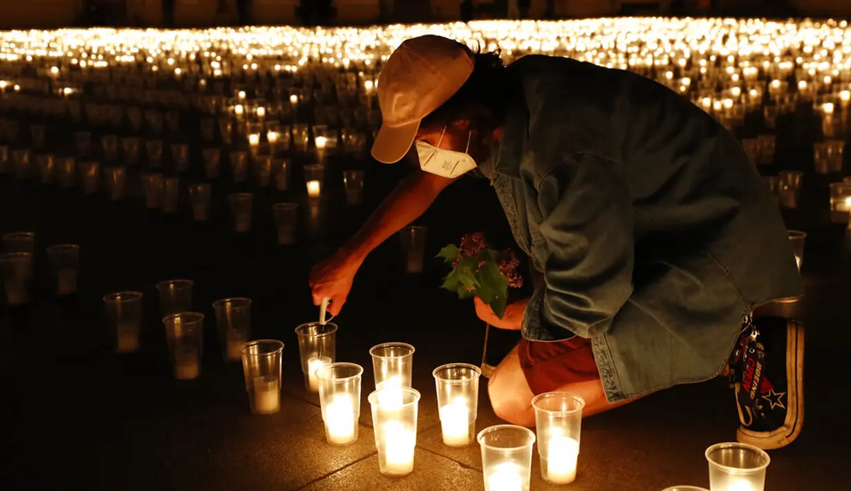 Seorang pria menyalakan lilin untuk memperingati para korban pandemi virus corona COVD-19 di Kastil Praha, Praha, Republik Ceko, Senin (10/5/2021). Republik Ceko melonggarkan pembatasan terkait COVID-19 secara besar-besaran kendati hampir 30 ribu orang telah meninggal. (AP Photo/Petr David Josek)