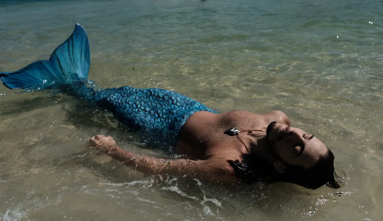 Davi de Oliveira Moreira bermain di Pantai Ipanema di Rio de Janeiro, Brasil, Rabu (3/5). Davi menjadi salah satu bagian dari penggila putri duyung yang sedang tumbuh di Brasil. ( AFP FOTO / YASUYOSHI CHIBA)
