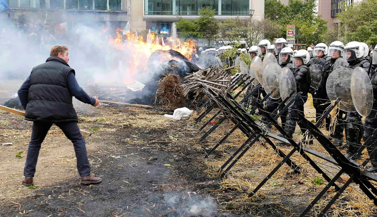 Peternak dan petani bentrok dengan polisi ditengah aksi protes saat pertemuan Menteri-menteri Eropoa di Brussels, Belgia, 7 September 2015. Aksi tersebut menuntut bantuan harga murah dan biaya yang tinggi. REUTERS/Yves Herman)