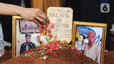 Foto almarhum Abdul Hamid alias Pak Ogah diletakan di atas makamnya di TPU (Tempat Pemakaman Umum) Jatisari, Bekasi, Jawa Barat, Kamis (29/12/2022). Pak Ogah salah satu pengisi suara dalam serial film Si Unyil meninggal pada (28/12/2022) di usia 74 tahun. (Liputan6.com/Herman Zakharia)