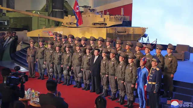 Pemimpin Korea Utara Kim Jong-un (tengah) berpose untuk foto bersama dengan pilot pesawat tempur yang melakukan penerbangan demonstrasi pada pembukaan pameran sistem senjata di Pyongyang, Korea Utara, Senin, Okt .11, 2021. (KCNA/AP)