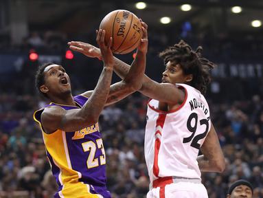 Pemain Los Angeles Lakers, Lou Williams #23 mencoba melakukan tembakan saat dihadang pemain Toronto Raptors pada laga NBA di Air Canada Centre, (2/12/2016). Raptors Menang 113-80. (Reuters/Tom Szczerbowski-USA TODAY Sports)