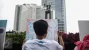 Seorang pengunjung mengikuti aksi melukis di kanvas disela kegiatan Car free Day (CFD) di kawasan Bundaran HI, Jakarta, Minggu (12/2). Aksi yang digelar oleh Greenpeace itu untuk mengenalkan masyarakat tentang sadar polusi. (Liputan6.com/Faizal Fanani)