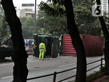 Petugas melakukan evakuasi Kontainer yang terguling di Jalan S Parman, Jakarta Barat, Senin (4/5/2020). Tidak ada korban jiwa dalam kecelakaan tersebut, namun kecelakaan tersebut membuat lalin dijalan itu terimbas kemacetan yang cukup panjang. (Liputan6.com/Johan Tallo)