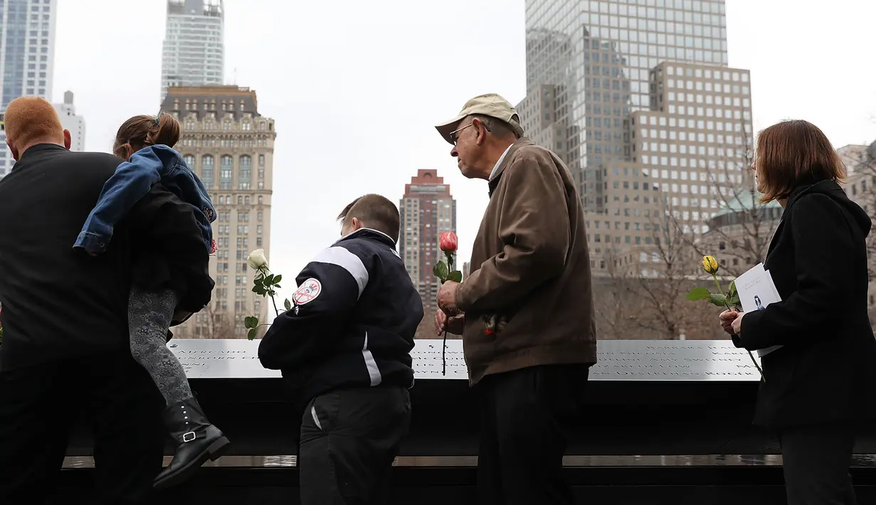 Orang-orang menaruh bunga mawar dalam peringatan 25 tahun serangan bom truk di WTC, New York City, Amerika Serikat, Senin (26/2). Bom yang meledak di garasi parkir bawah tanah tersebut diluncurkan oleh ekstremis. (Spencer Platt/Getty Images/AFP)
