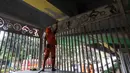 Bersama jajaran Suku Dinas Bina Marga, petugas PPSU melakukan pengecatan ulang, pembuatan mural, pembersihan debu, serta perapian tanaman di jalur hijau sekitar arena. Tampak dalam foto, salah satu petugas Penanganan Prasarana dan Sarana Umum (PPSU) melakukan pengecatan di kolong jembatan layang Pasar Rebo, Jakarta Timur, Jumat (8/5/2026). (Kapanlagi.com/Budy Santoso)