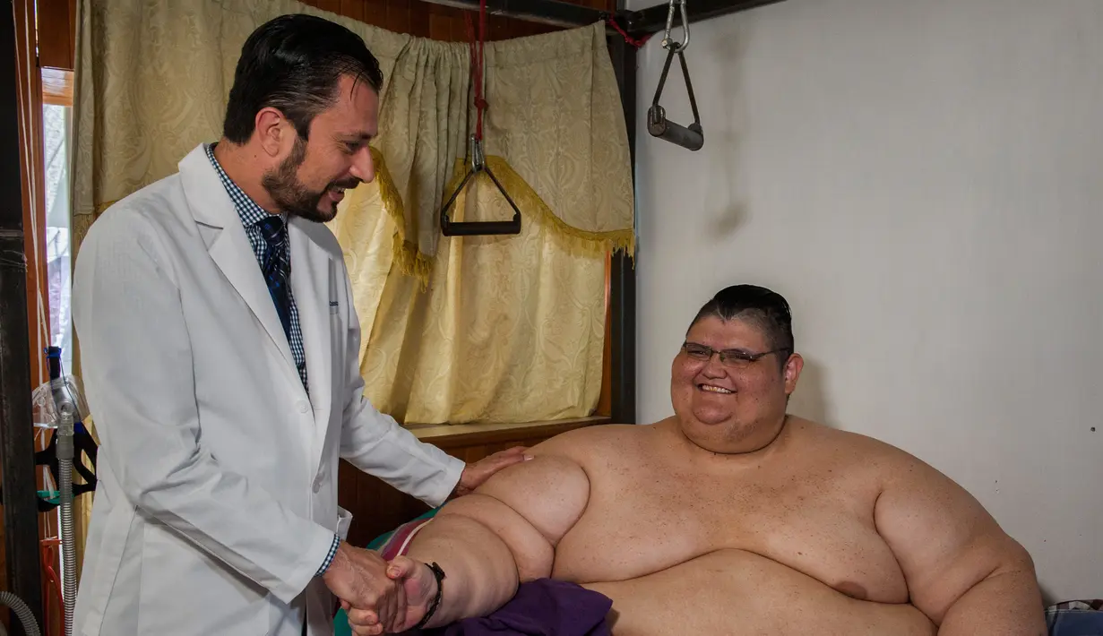 Juan Pedro Franco bersama dokter yang merawatnya selama ini di kediamannya di Guadalajara, Meksiko (28/3). Pria tergemuk di dunia ini berat badannya turun 170 kilogram setelah dirinya mengikuti diet selama 4 bulan. (AFP Photo / Hector Guerrero)