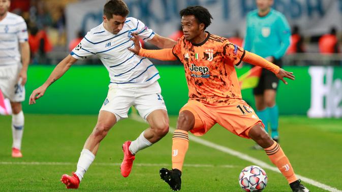 Gelandang Juventus, Juan Cuadrado berebut bola dengan pemain Dynamo Kiev, Artem Shabanov pada laga pembuka penyisihan Grup G Liga Champions di Stadion NSK Olimpiyskiy, Rabu (21/10/2020) dinihari. Tak diperkuat Cristiano Ronaldo, Juventus menang 2-0 atas Dynamo Kiev. (Valentyn Ogirenko/Pool via AP)