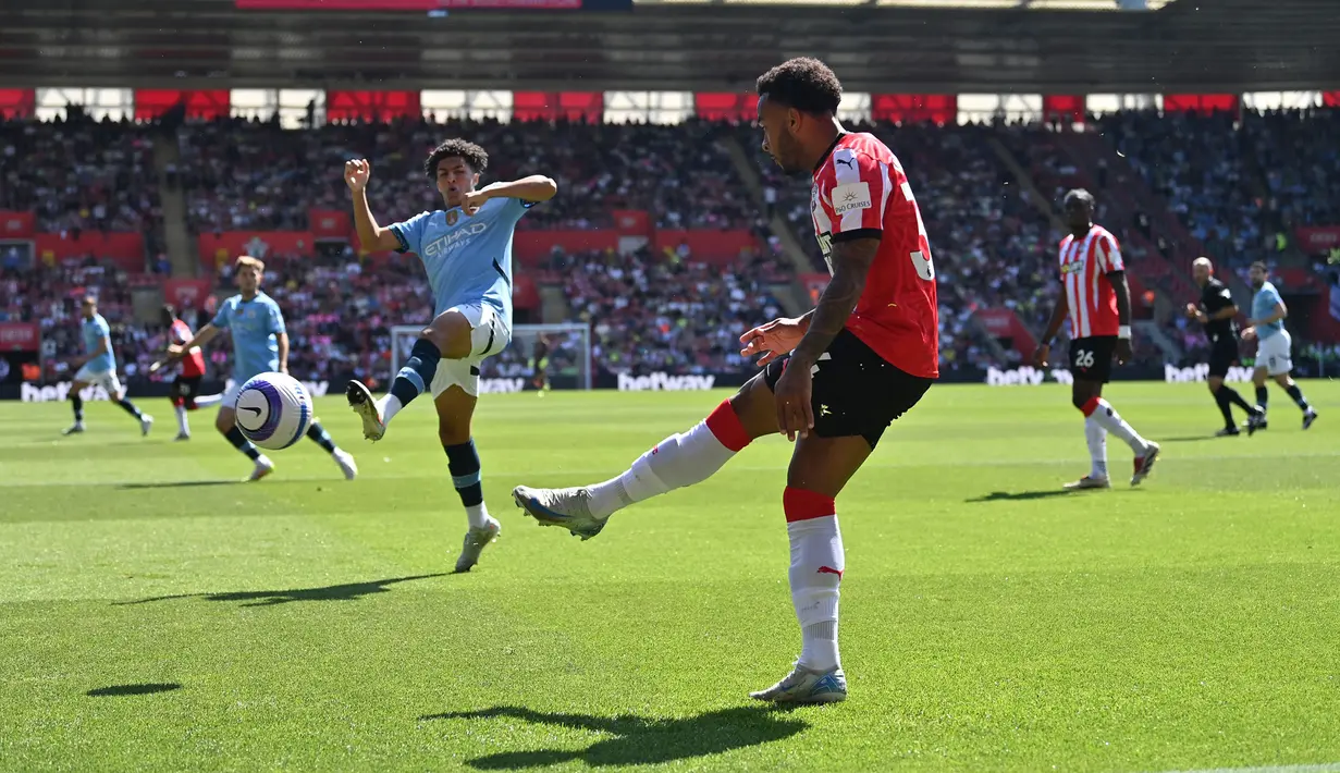 Pemain Manchester City, Mateus Fernandes berusaha menghalau bola tendangan pemain Southampton, Welington dalam laga lanjutan Liga Inggris 2024/2025 di St Mary's Stadium, Southampton, Inggris, Sabtu (10/05/2025) waktu setempat. (AFP/Glyn Kirk)