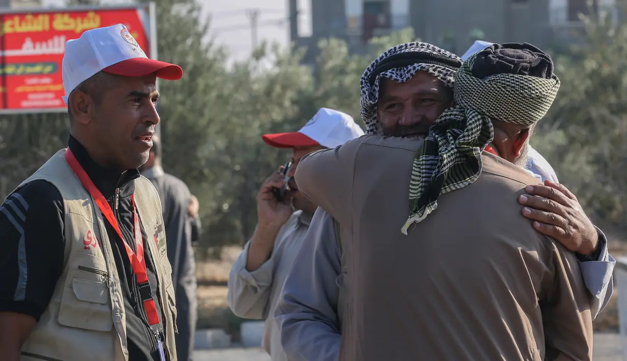 Calon jemaah haji Palestina memeluk kerabatnya sebelum saat akan berangkat menuju Makkah di perbatasan Jalur Gaza dengan Mesir, Rafah, Kamis (25/7/2019). Calon jemaah haji Palestina menyeberang ke Mesir untuk kemudian diterbangkan dengan pesawat ke Arab Saudi. (SAID KHATIB/AFP)
