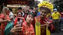 Orang-orang berfoto di sepanjang Jalan Yaowarat di Chinatown di Bangkok, 10 Februari 2024, pada hari pertama Tahun Baru Imlek Naga. (Lillian SUWANRUMPHA/AFP)