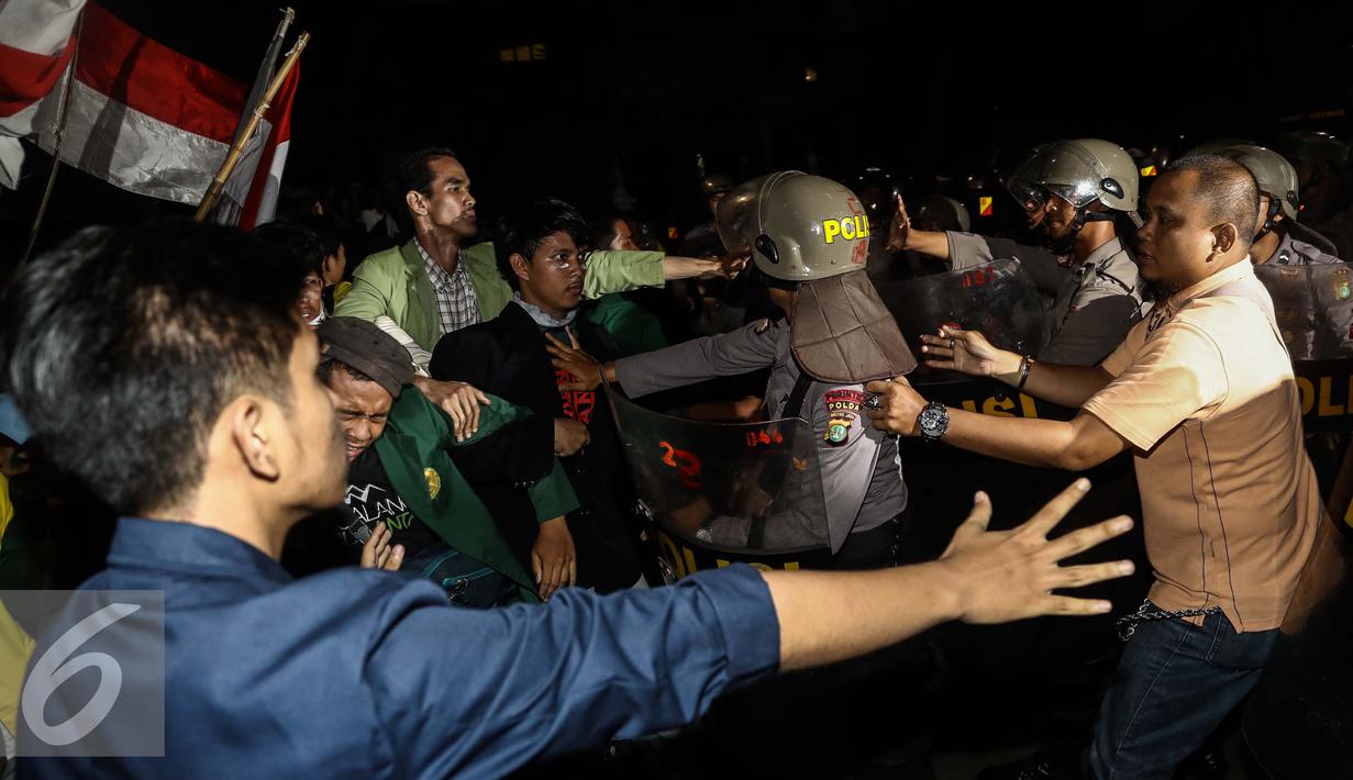 Aksi saling dorong antara massa dengan polisi saat unjuk rasa di depan Istana Negara, Kamis (12/1). Aksi sejenis dilakukan serentak di 19 titik kota berbeda di Indonesia. (Liputan6.com/Faizal Fanani)
