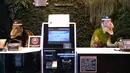 Sepasang robot dinosaurus menyambut para tamu dari meja resepsionis Hotel Henn-na di Urayasu, Tokyo, 31 Agustus 2018. Hotel ini berbeda pada umumnya, seluruh staf atau pekerjanya adalah robot, termasuk dinosaurus menjadi resepsionis. (AFP/Kazuhiro NOGI)