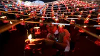 Warga menyalakan lilin sebelum melepaskan lampion buatan tradisional ke langit selama festival tahunan Tazaungdaing di Taunggyi, Myanmar (19/11). (REUTERS/Soe Zeya Tun)