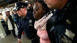 Seorang perempuan tersangka pelaku pendorongan ditangkap petugas NYPD pendorongan di stasiun Time Square, New York, Senin (7/11). Tersangka diidentifikasi sebagai Melanie Liverpool-Turner namun motifnya belum diketahui. (REUTERS/James Carman)