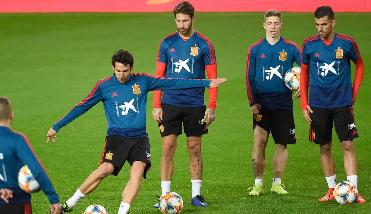Bek Spanyol, Sergio Ramos (ketiga kanan) melihat gelandang Daniel Parejo menendang bola selama sesi pelatihan di stadion Mestalla di Valencia (22/3). Spanyol akan bertanding melawan Norwegia pada grup F kualifikasi Euro 2020. (AFP Photo/Jose Jordan)