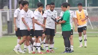 Pelatih Timnas Indonesia U-17, Bima Sakti, memberikan arahan kepada anak asuhnya saat sesi latihan di Lapangan ABC, Kompleks Gelora Bung Karno, Kamis (27/7/2023). (Bola.com/Abdul Aziz)