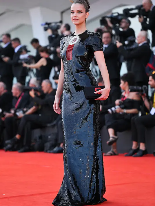 Barbara Palvin berpose saat tiba di pemutaran perdana film 'White Noise' dan upacara pembukaan Festival Film Venesia edisi ke-79 di Venesia, Italia, Rabu (31/8/2022). Gould menata rambut Palvin, yang disatukan dengan jepit rambut yang ditempatkan dengan ahli, dengan hairspray berkilauan yang membuat sanggul ularnya berkilau di bawah kilatan kamera. (AFP/ TIZIANA FABI)