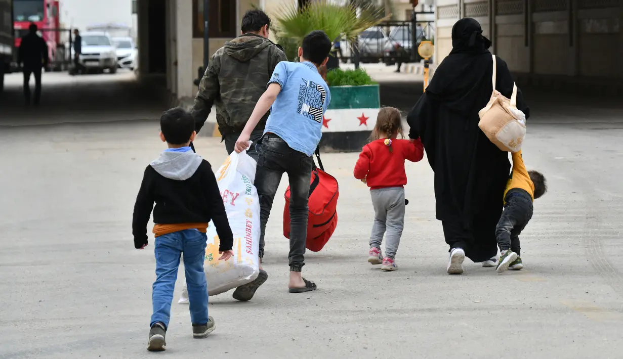 Warga Suriah yang datang dari Turki melewati penyeberangan Bab al-Salame di kota perbatasan Azaz di utara provinsi Aleppo yang dikuasai pemberontak, Senin (18/4/2022). Mereka akan menghabiskan hari-hari terakhir Ramadhan dan liburan Idul Fitri bersama keluarga di Suriah. (Rami al SAYED/AFP)