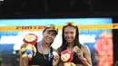 Pevoli Pantai Indonesia, Juliana/Utami memamerkan Medali Juara usai mengalahkan pevoli Thailand Numwong/Hongpak pada Kejuaraan Bola Voli Pantai ke-29 yang diadakan di Singapura, Rabu (30/9/2017) (Bola.com/Wong Foo Lam)