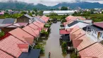 Foto udara menunjukkan seorang pria melintasi banjir setelah hujan deras di permukiman Darul Imarah di pinggiran Banda Aceh pada Kamis 27 November 2025. Curah hujan tinggi yang dipicu siklon tropis menyebabkan sejumlah wilayah di Aceh Besar, termasuk Darul Imarah, terendam banjir. (CHAIDEER MAHYUDDIN/AFP)