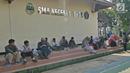 Siswa dan orangtua murid menunggu saat mengikuti seleksi Penerimaan Peserta Didik Baru (PPDB) di SMAN 1 Depok, Kota Depok, Jawa Barat, Selasa (18/6/2019). Sistem PPDB Jawa Barat berlangsung pada tanggal 17-22 Juni 2019. (Liputan6.com/Herman Zakharia)