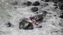 Seorang pria dievakuasi dengan menyeberangi sungai setelah sebuah bus jatuh dari tebing di Pasamayo, Peru, Selasa (3/1). Bus  yang membawa sekitar 53 penumpang tersebut jatuh ke dalam jurang setinggi 100 meter. (Vidal Tarky, Andina News Agency via AP)