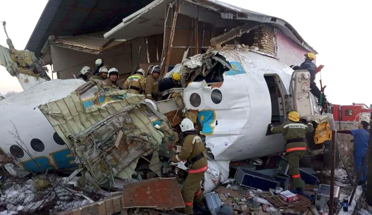 Polisi dan petugas penyelamat di antara puing-puing  pesawat maskapai Bek Air yang jatuh di dekat Bandara Almaty, Kazakhstan, Jumat (27/12/2019). Pesawat yang mengangkut 100 orang itu jatuh sesaat setelah lepas landas.  ( Emergency Situations Ministry of the Republic of Kazakhstan photo via AP)