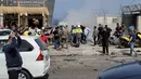 Petugas pertolongan pertama dan warga yang lewat berkumpul di sekitar reruntuhan kendaraan yang menjadi sasaran serangan pesawat tak berawak Israel di kota Jiyeh, Selatan Beirut, pada Rabu 13 Mei 2026. (Fadel ITANI/AFP)