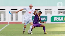 Pemain PSM Makassar, Anco Jansen, berebut bola dengan pemain Persik Kediri, Ibrahim Sanjaya, pada laga BRI Liga 1 di Stadion Wibawa Mukti, Cikarang, Kamis (23/9/2021). PSM Makassar menang tipis atas Persik Kediri dengan skor 3-2. (Bola.com/M Iqbal Ichsan)